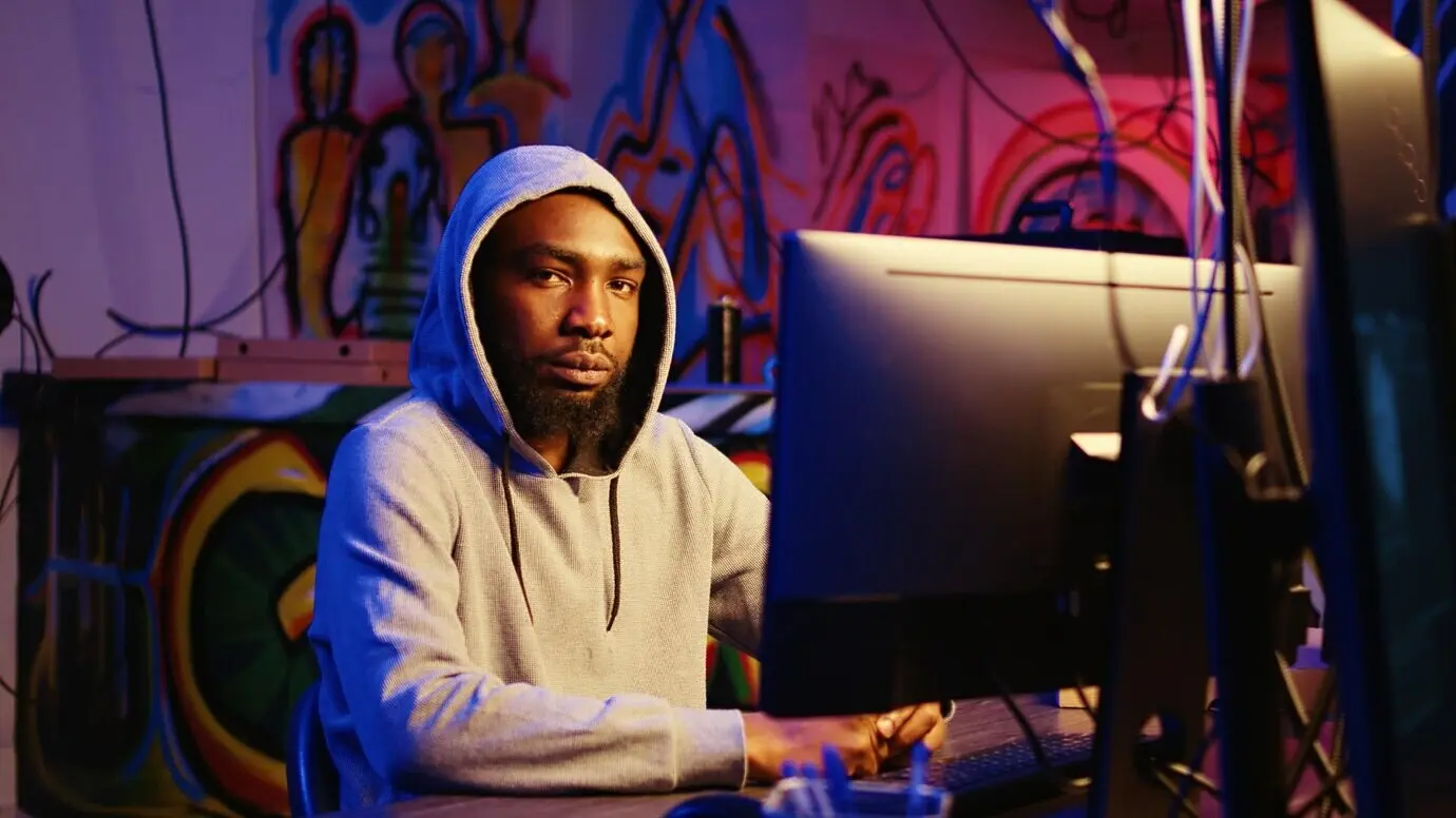 Мужчина, взламывающий системы и похищающий данные.